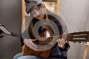 Girl playing acoustic guitar. Musician woman in studio with classic guitar