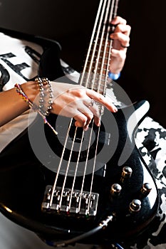 Girl playing Bass guitar indoor