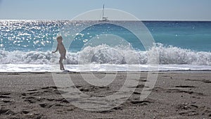 Girl Playing on Beach, Kid Running on Seashore at Sunset, Little Child Watching Sea Waves on Coastline Shore in Summer Vacation