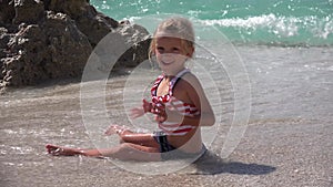 Girl Playing on Beach in Sunset, Kid in Sea Waves on Seashore, Baby Little Child Plays on Coastline at Seaside in Summer Vacation