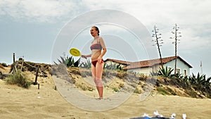 girl playing beach tennis on a summer day. Beach games. Woman in a red bikini.