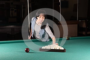 Girl playing billiards. woman holding the cue stick