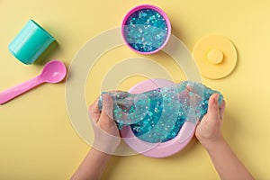 girl playing with blue slime and toy kitchen utensils