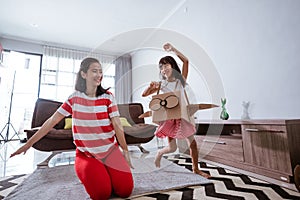 girl playing with cardboard toy airplane at home