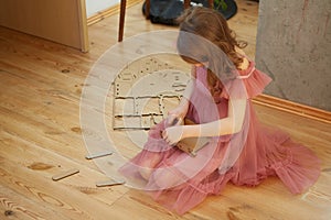 A girl playing with Cardboard Toy Dollhouse Furniture.