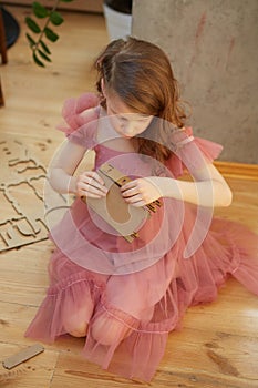 A girl playing with Cardboard Toy Dollhouse Furniture.