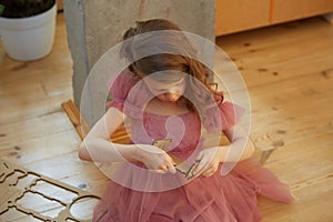 A girl playing with Cardboard Toy Dollhouse Furniture.