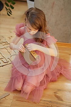 A girl playing with Cardboard Toy Dollhouse Furniture.