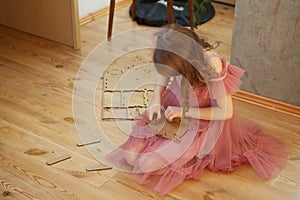 A girl playing with Cardboard Toy Dollhouse Furniture.