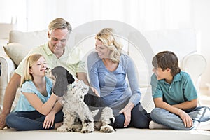 Girl Playing With Dog While Family Looking At Her