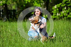 Girl playing with a dog in the park. In the hands of the stick.