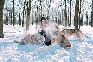 Girl playing with dogs in snow