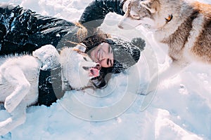 Girl playing with dogs in snow