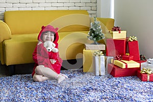 Girl playing doll. X-mas and holiday concept. Happy childen girl with gift box. Girl in christmas cap hands present wrapped with
