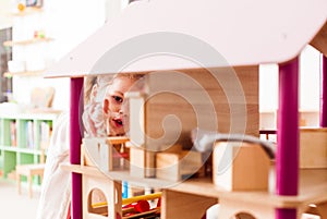 Girl playing with a dollhouse