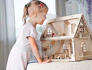 A girl playing with a dollhouse