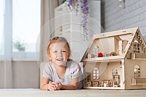 A girl playing with a dollhouse