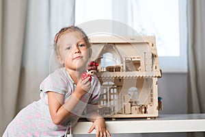 A girl playing with a dollhouse