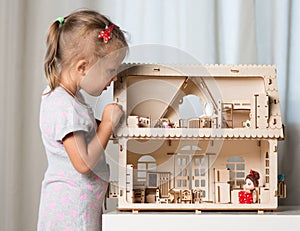 A girl playing with a dollhouse