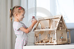 A girl playing with a dollhouse