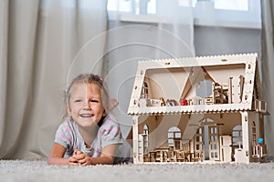 A girl playing with a dollhouse