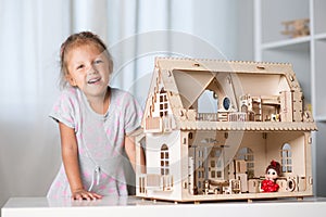 A girl playing with a dollhouse