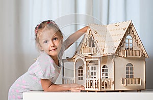 A girl playing with a dollhouse