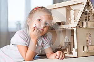 A girl playing with a dollhouse