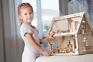 A girl playing with a dollhouse