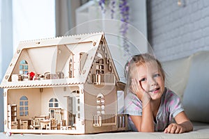 A girl playing with a dollhouse