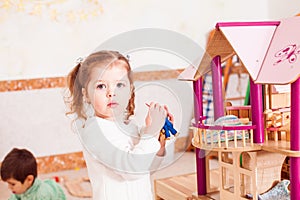 Girl playing with a dollhouse