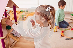 Girl playing with a dollhouse