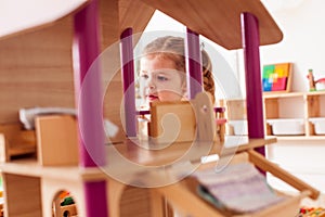 Girl playing with a dollhouse