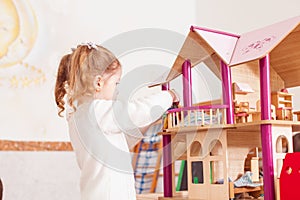 Girl playing with a dollhouse