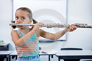 Girl playing flute in classroom