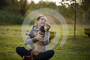 Girl playing with French Billdog at the park