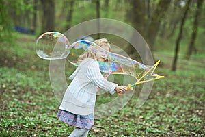 girl playing with giant soap bubble. Girl blowing large bubbles