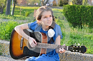 Girl playing guitar in nature