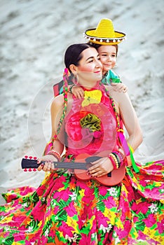 Girl playing the guitar on sand background