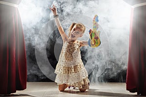 Girl playing guitar on stage