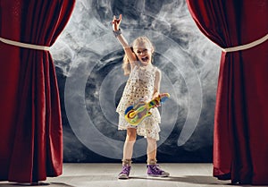 Girl playing guitar on stage