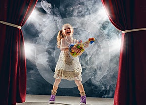 Girl playing guitar on stage