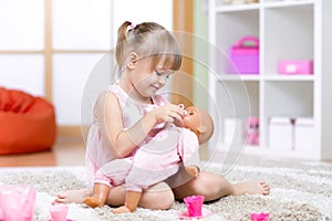 Girl playing with her baby-doll