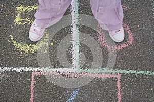 Girl Playing Hop-Scotch In Playground