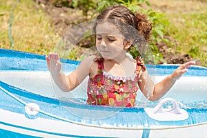 Girl playing in inflatable boat with water