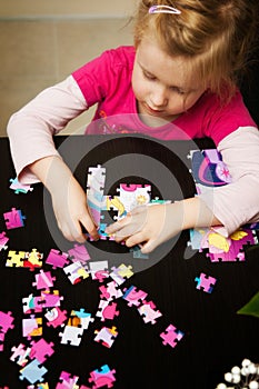 Girl playing with jigsaw puzzle