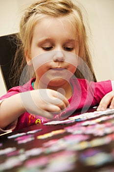 Girl playing with jigsaw puzzle