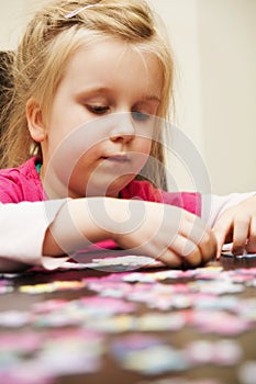 Girl playing with jigsaw puzzle