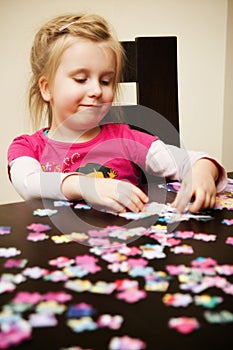 Girl playing with jigsaw puzzle