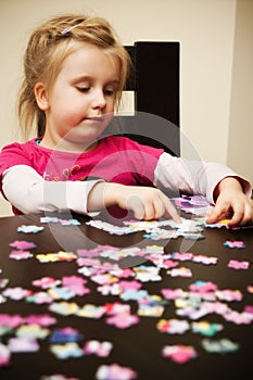 Girl playing with jigsaw puzzle